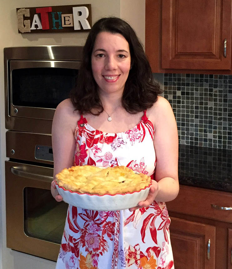 Woman proudly presents homemade pie.