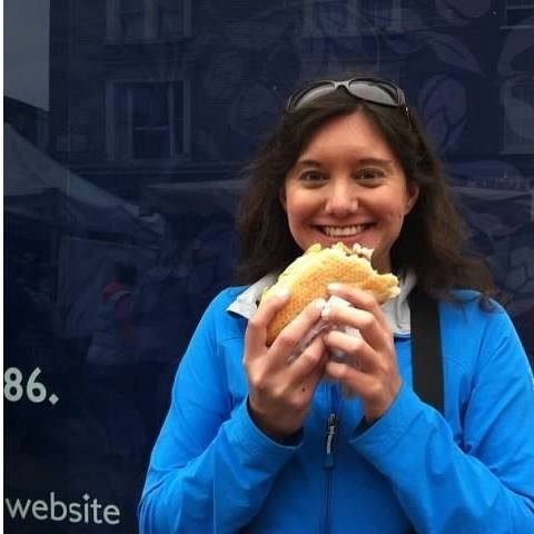 Woman eating a sandwich outdoors.