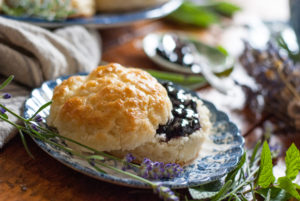 A biscuit with blueberry jam on it.